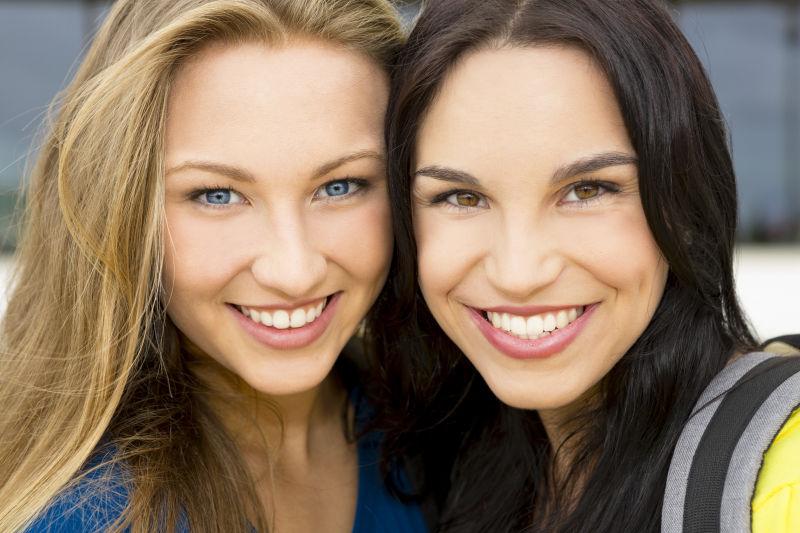 户外背景下微笑的两个美女