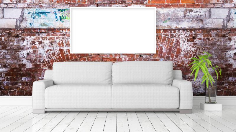 红色砖墙前的空白框架和绿植旁的白色沙发