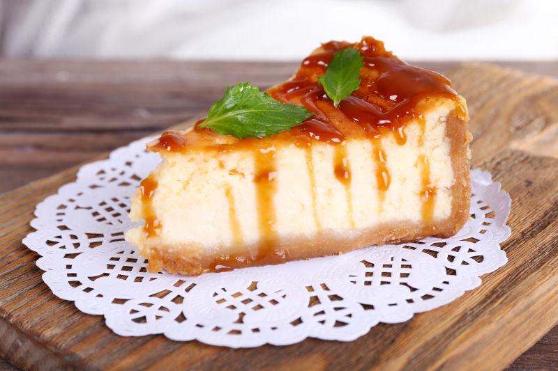 浅色背景木桌上餐巾纸上的奶酪蛋糕