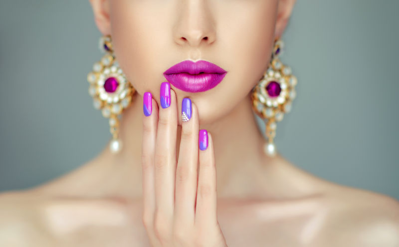 紫色的化妆和紫色的美甲的美女