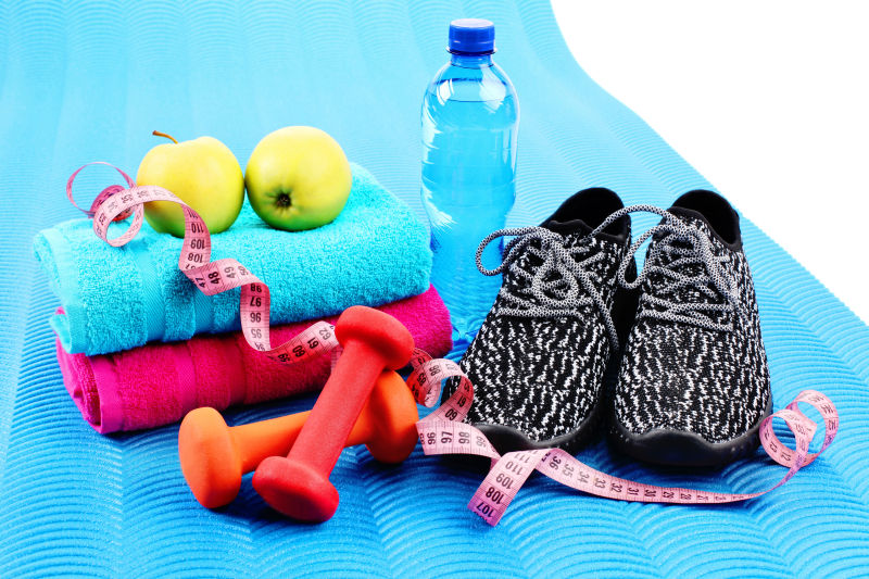 蓝色瑜伽垫上的运动物品和苹果减肥