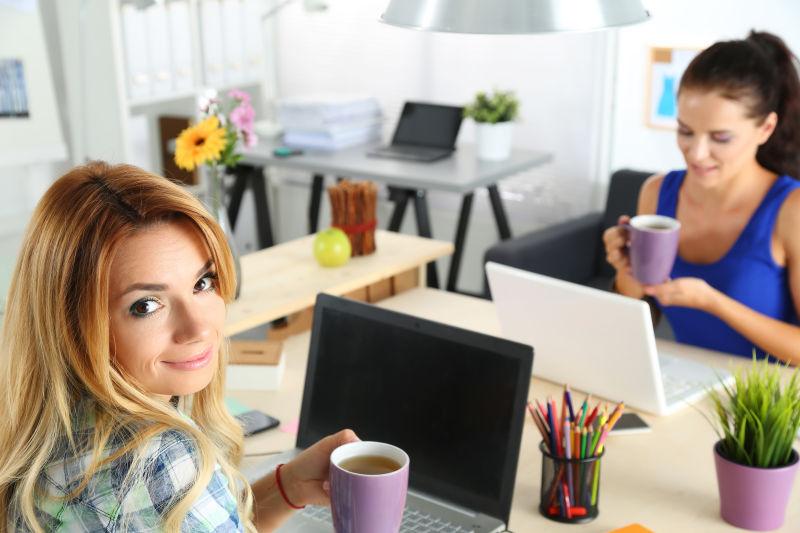 两位女性设计师在办公室喝早茶