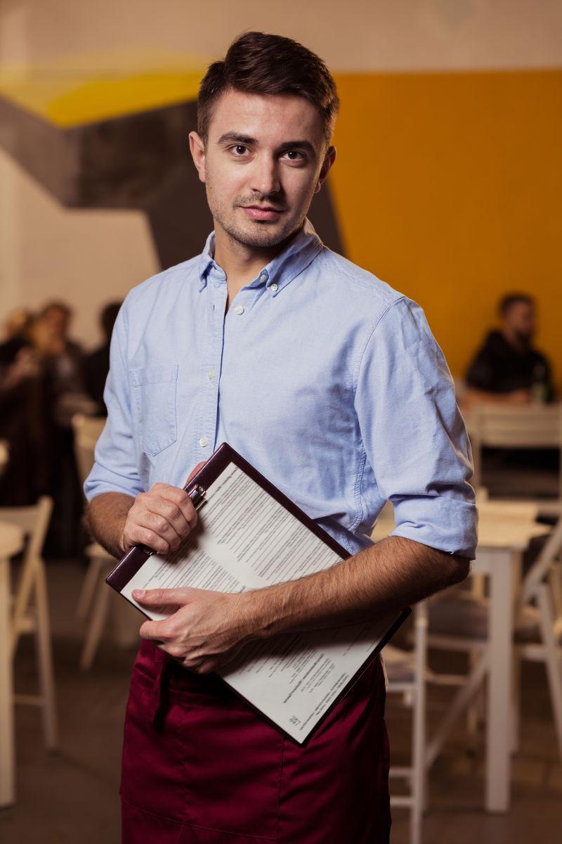 手拿菜单的年轻服务员