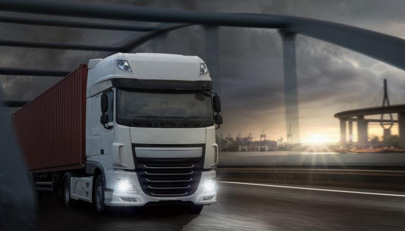 日出时行驶在公路上的白色货车