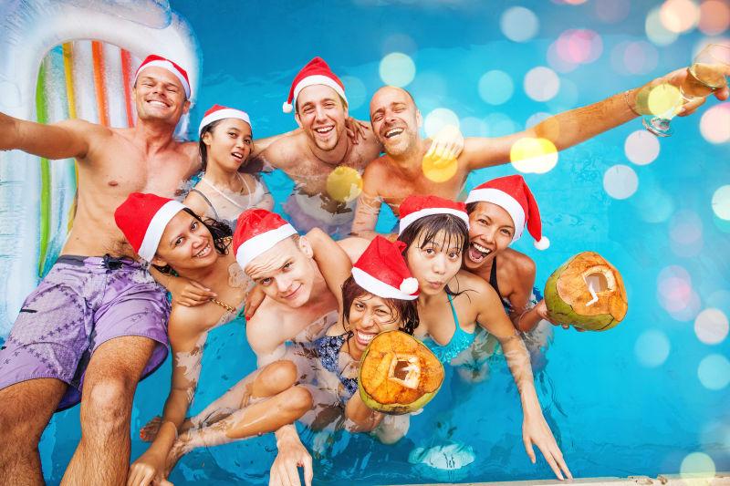 九人在游泳池里庆祝圣诞节的混合赛跑团体