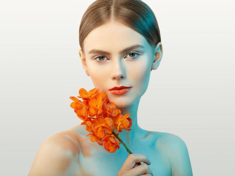 美丽的年轻女子拿着兰花