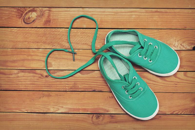 一双鞋带的顶视图在木制地板上制作了心形