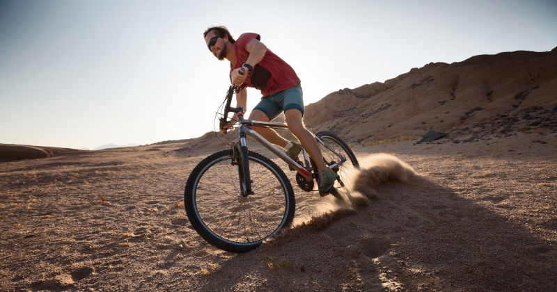 在沙漠中骑自行车的男人