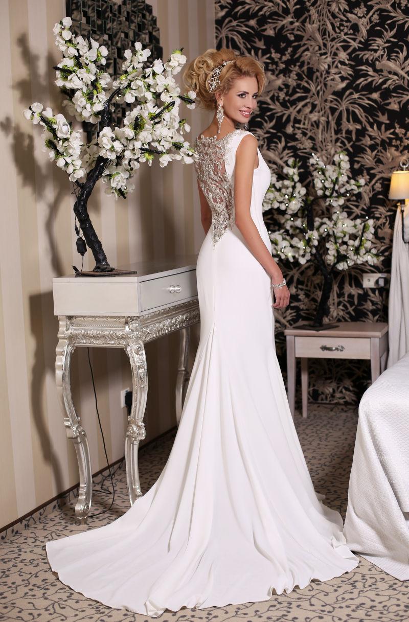 摆在装修室的穿着豪华婚纱与双娇的华丽的新娘金发