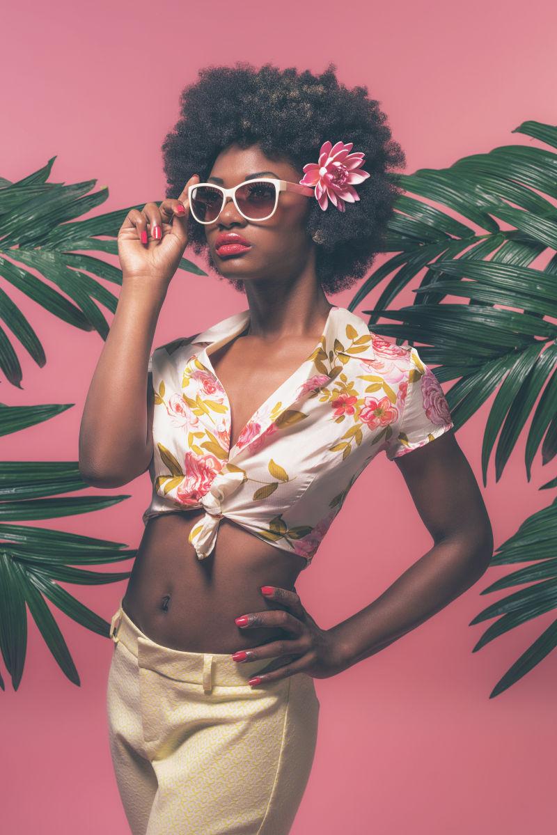 非洲裔美国人用太阳镜夹在棕榈叶之间