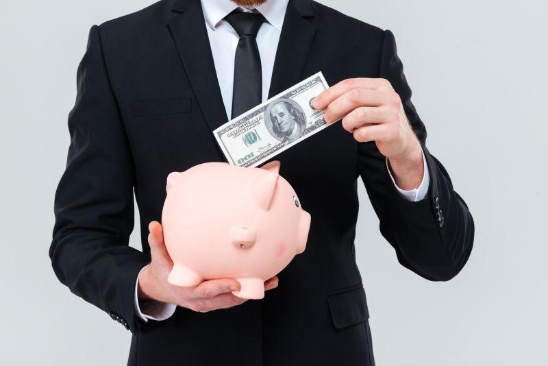 男子将纸币放入存钱罐