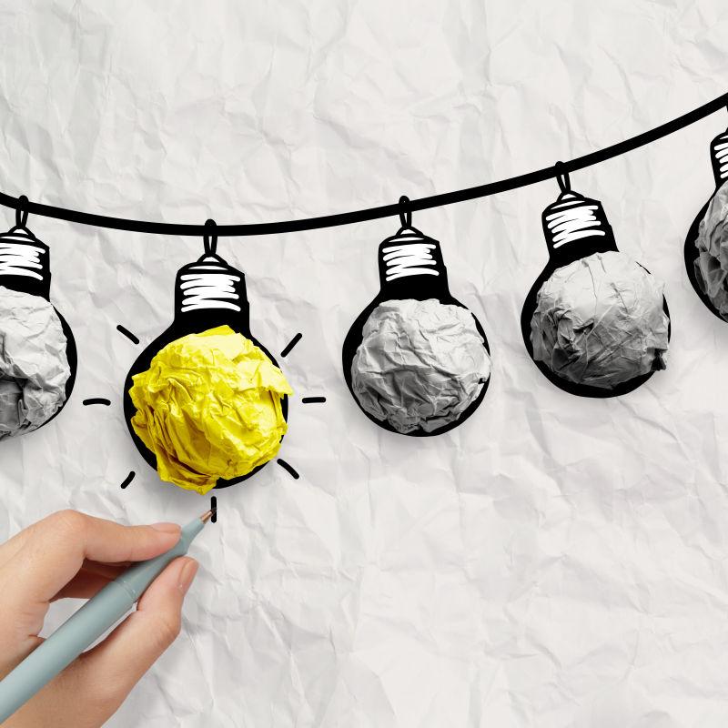 手绘灯泡在电线涂鸦与弄皱的纸作为领导观念的概念