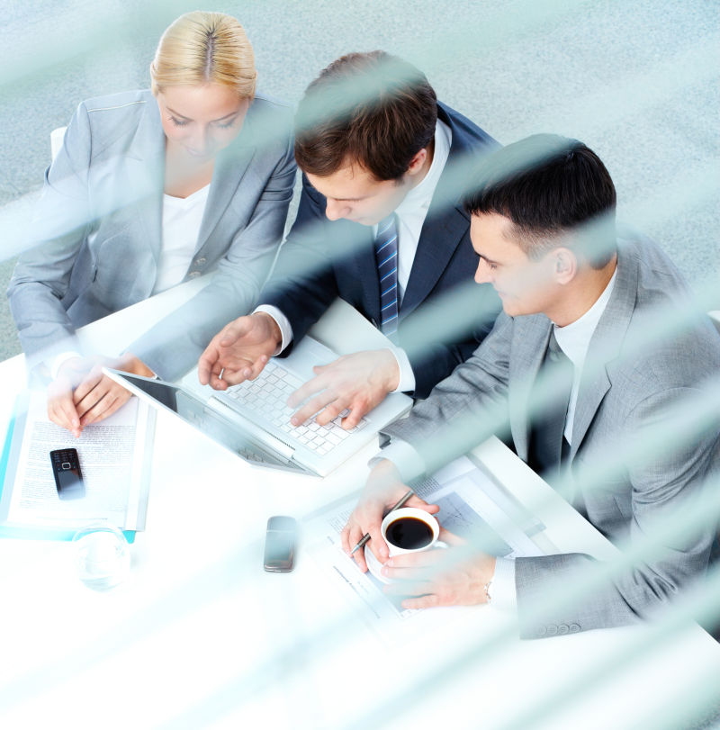 三个看着笔记本电脑讨论的商人