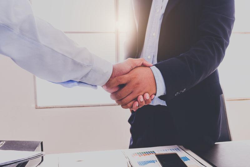 办公桌边握手的商人