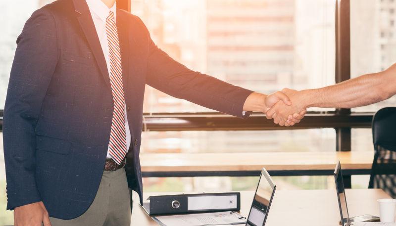 夕阳下握手的商务人士