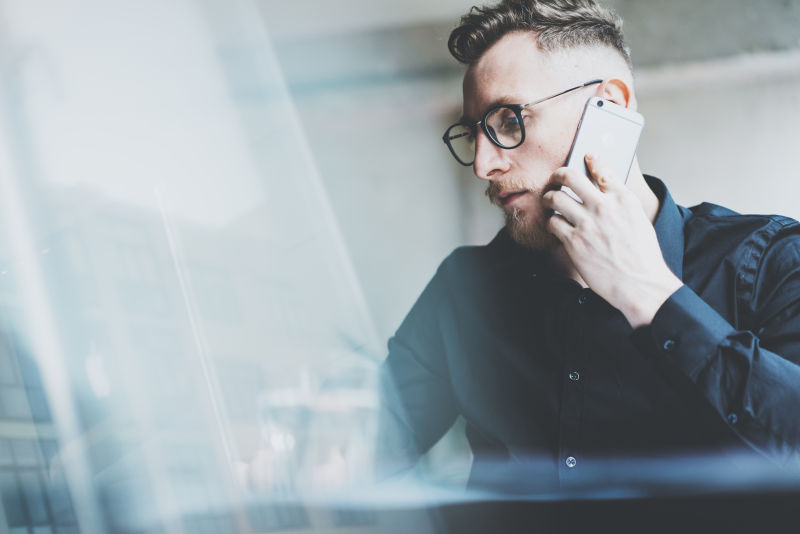 电脑桌前接着电话的男人