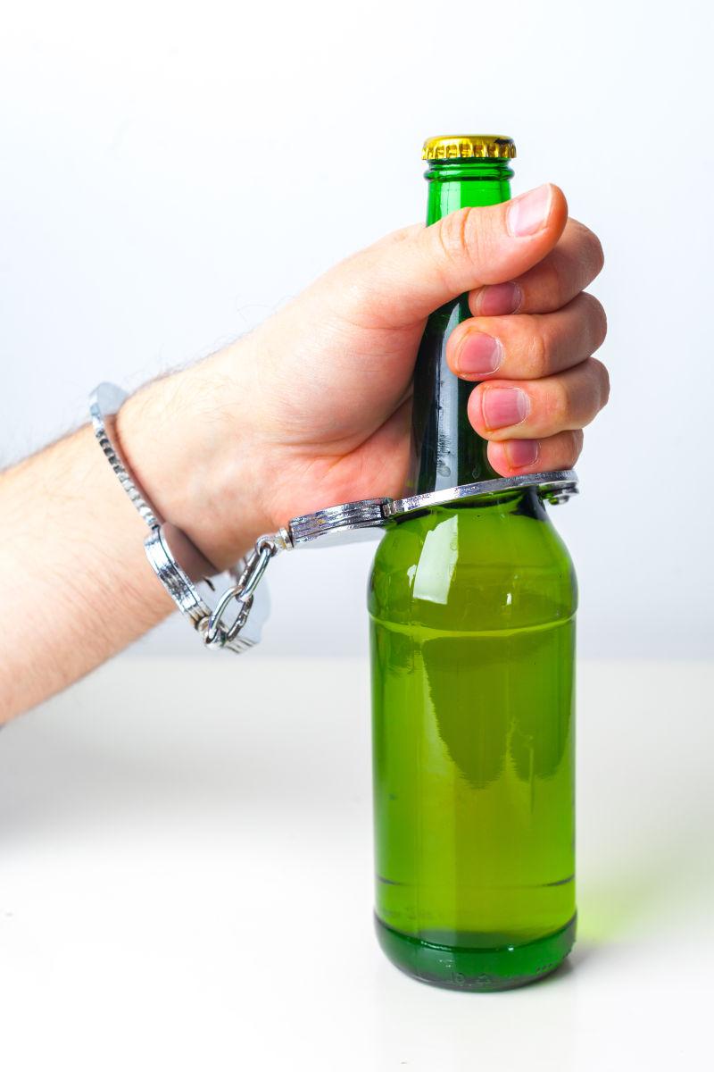 以手铐为酒精滥用标志的啤酒杯
