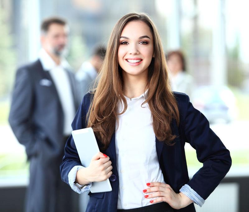 站在前台的女商人手里拿着一块写字板