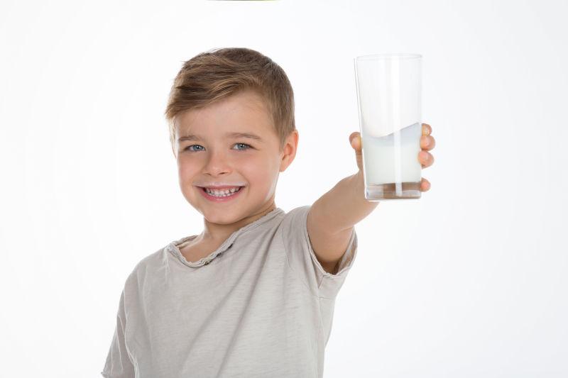 小孩展示了一杯满是牛奶的杯子