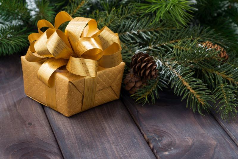 杉树旁边的金色礼品盒