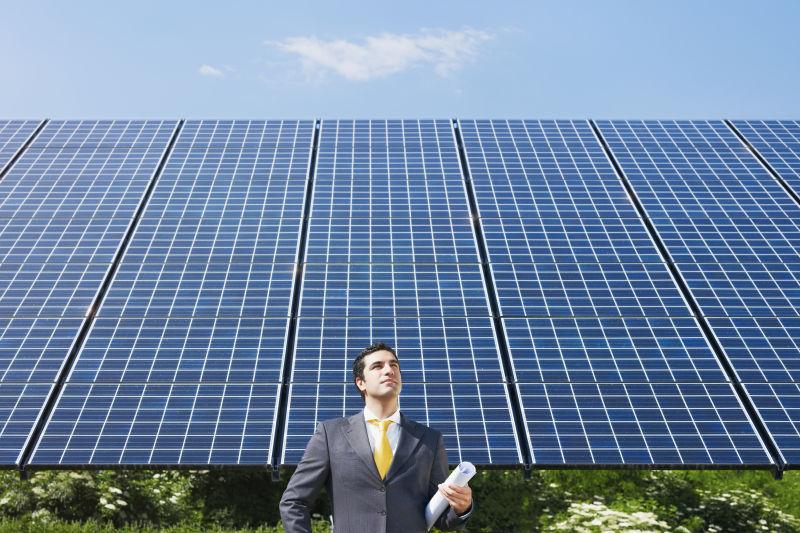 站在太阳能电池板旁边的商人