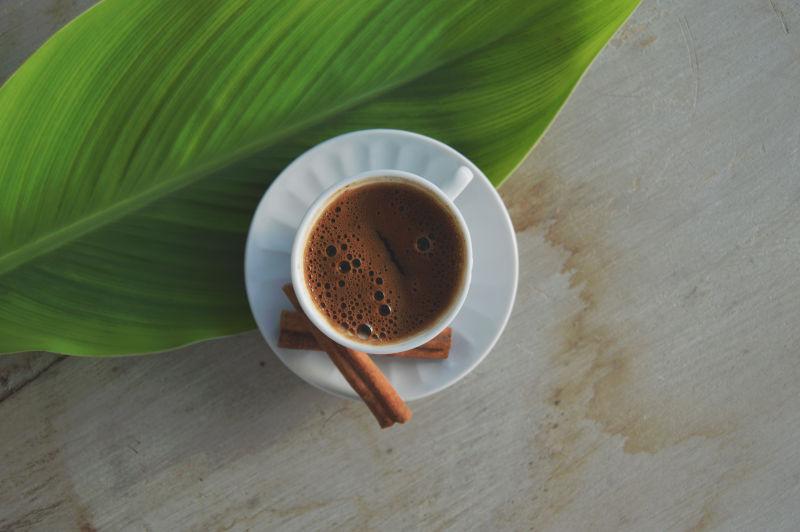 木桌上的咖啡和树叶