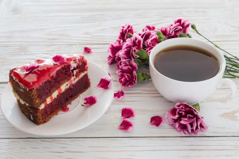 咖啡蛋糕和粉红康乃馨在木桌上