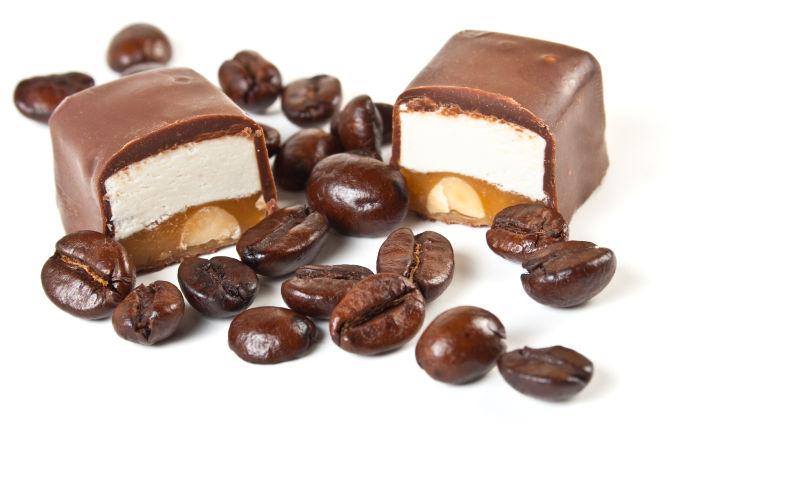 白色背景下的甜巧克力和咖啡豆