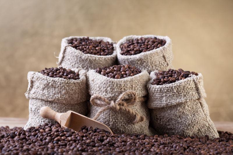 黄色背景下装满咖啡豆的小麻袋