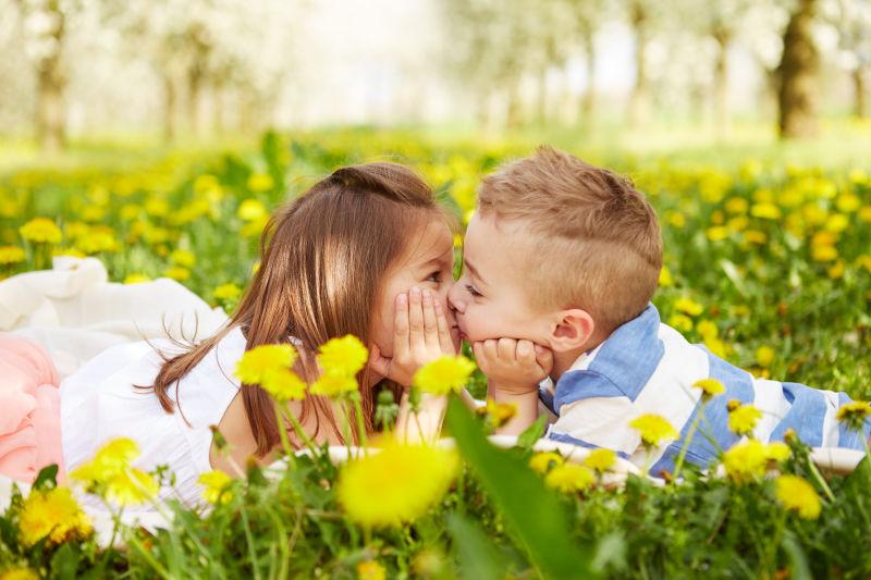 在一个开花的果园里亲吻一个男孩的女孩