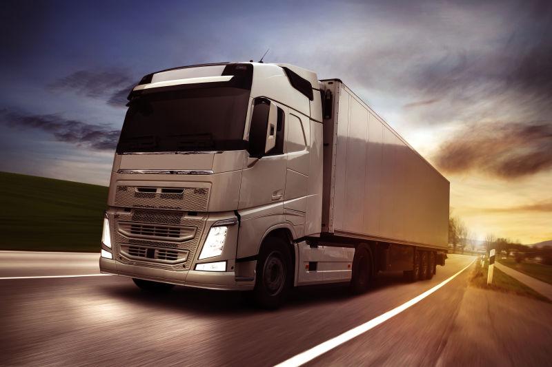 傍晚时行驶在公路上的货车