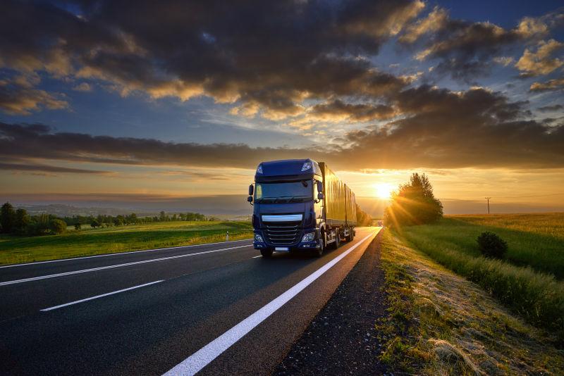 日出时在公路上行驶的货车