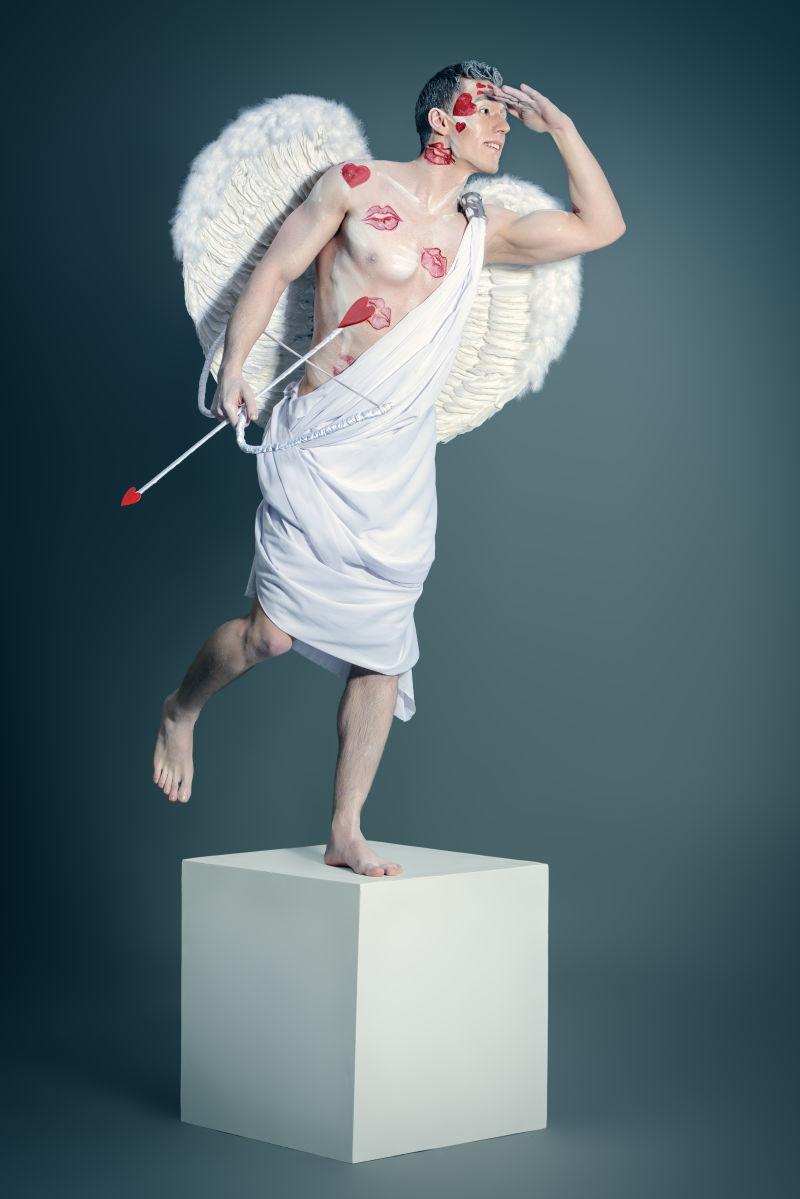 一个男人Cupid天使摆姿势像一尊雕像