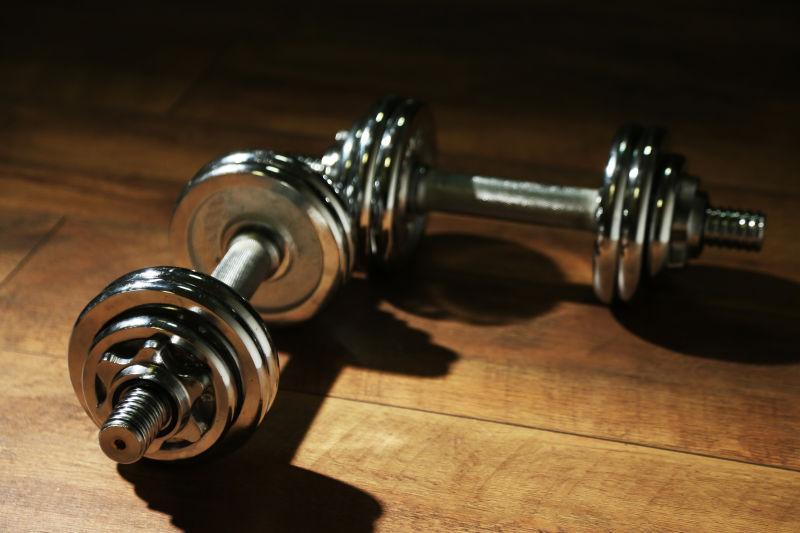 黑暗背景木地板上的哑铃