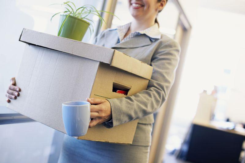 抱着纸箱拿着杯子的女人