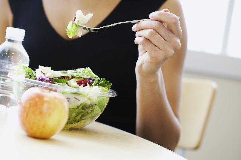 办公室里吃蔬菜沙拉的美女