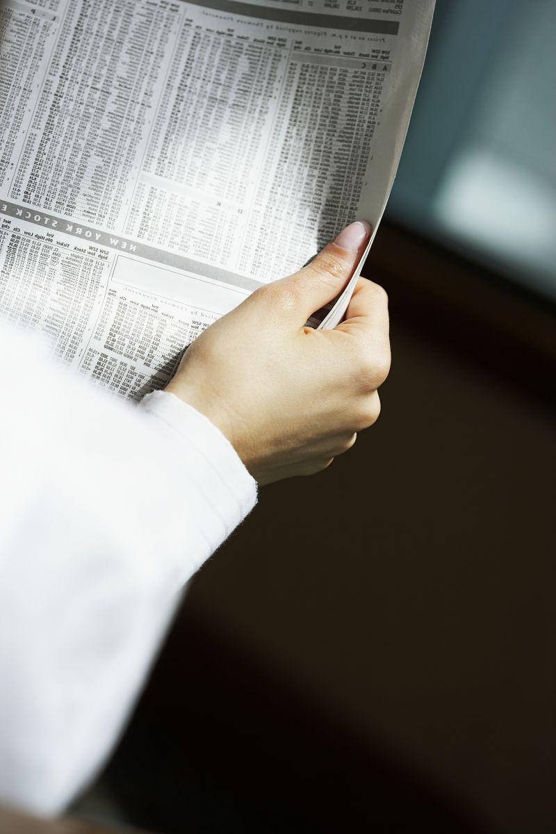 阳光下拿着报纸看的人