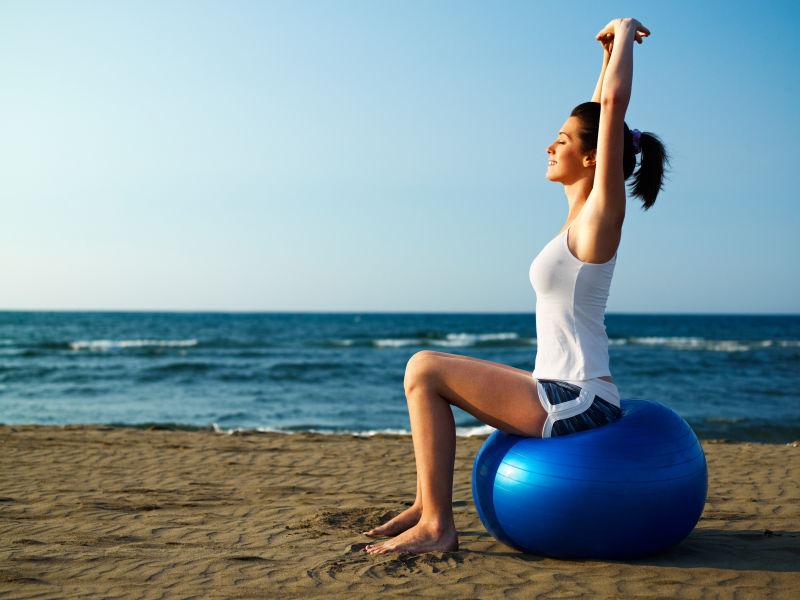 海滩上正在练瑜伽的美女