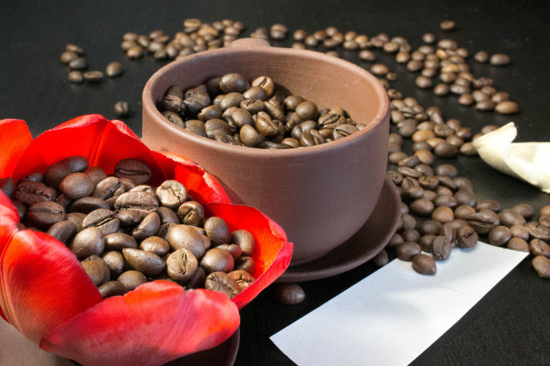 放在木碗与花朵中的咖啡豆