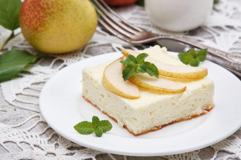 白色盘子里的梨芝士蛋奶酥蛋糕