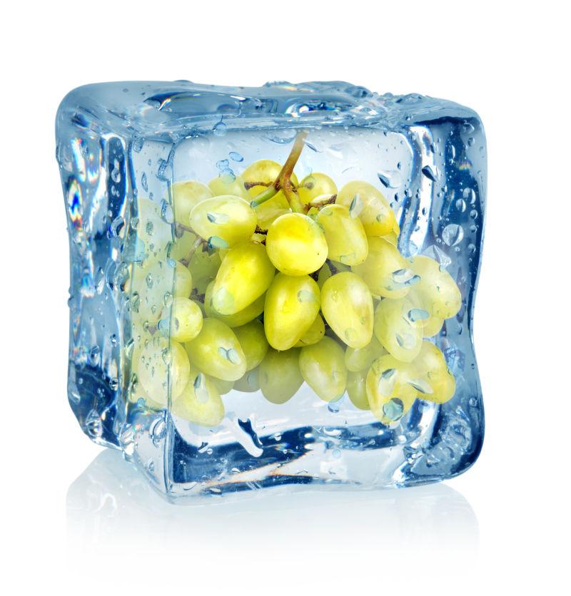 白色背景下的冰块和绿色葡萄