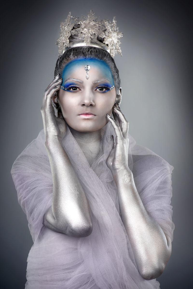 灰色背景中化妆带着皇冠的女王