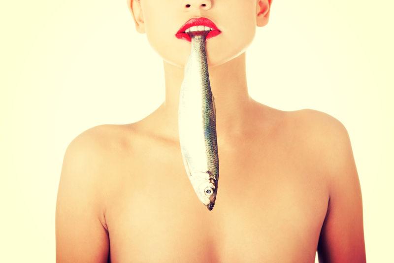 嘴里叼着鱼的美丽的女人