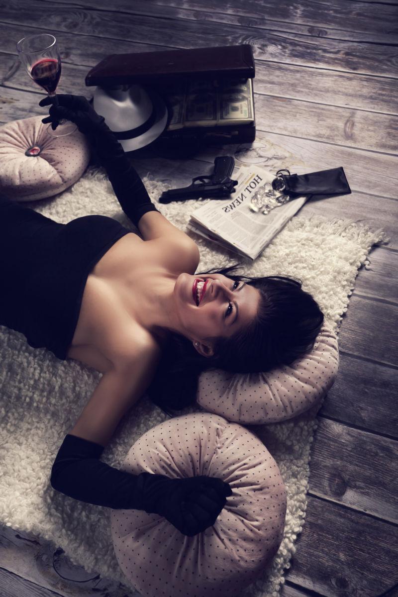 躺在毛毯上喝红酒的美女