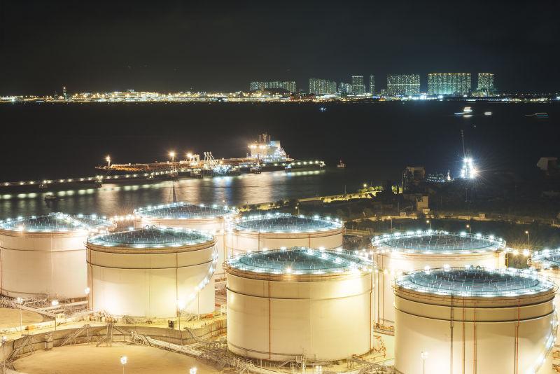 黑色背景下的油罐和油船