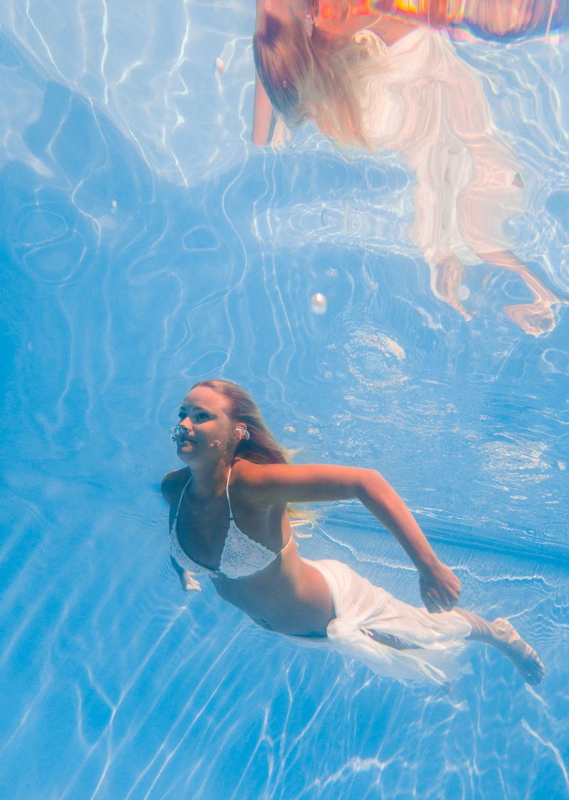 游泳池水中游泳的年轻女子