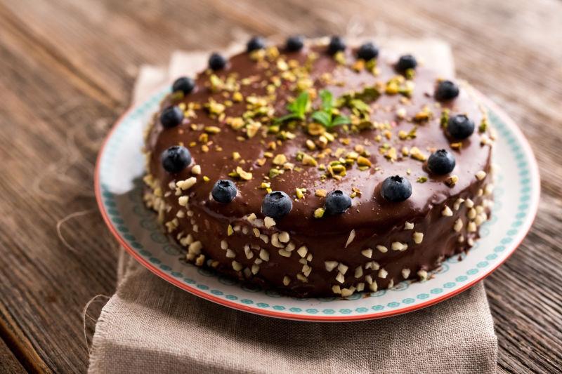 木制背景下盘子里的美味的巧克力蛋糕