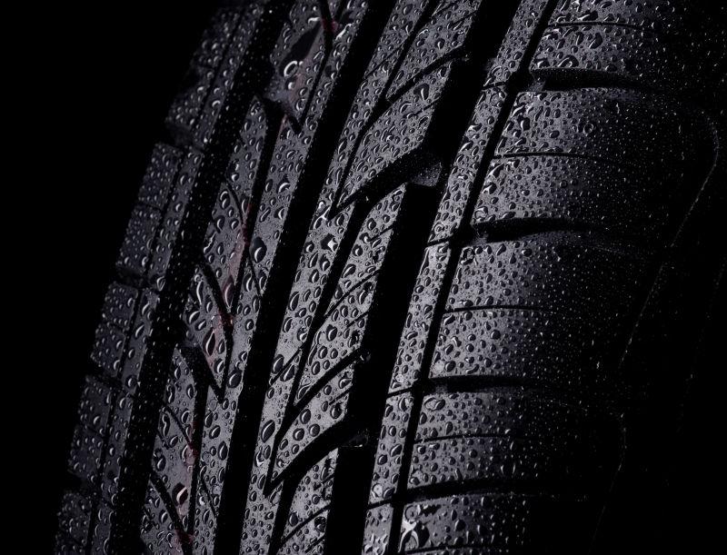 黑色背景下的汽车湿轮胎