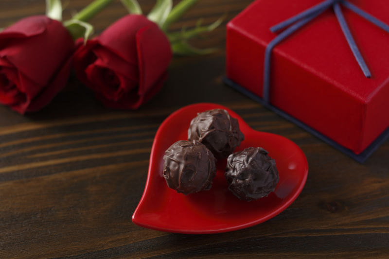 情人节巧克力和红色玫瑰在木桌上
