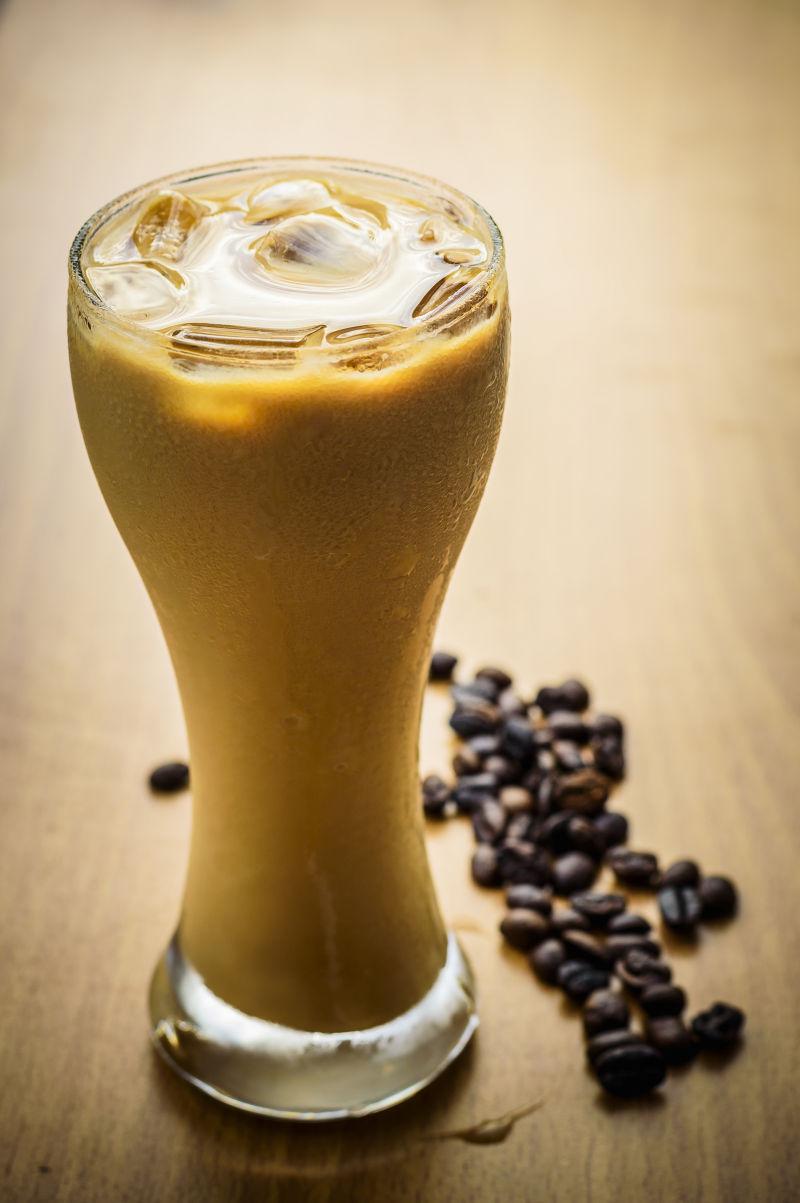 木板上的一杯咖啡和散落的咖啡豆